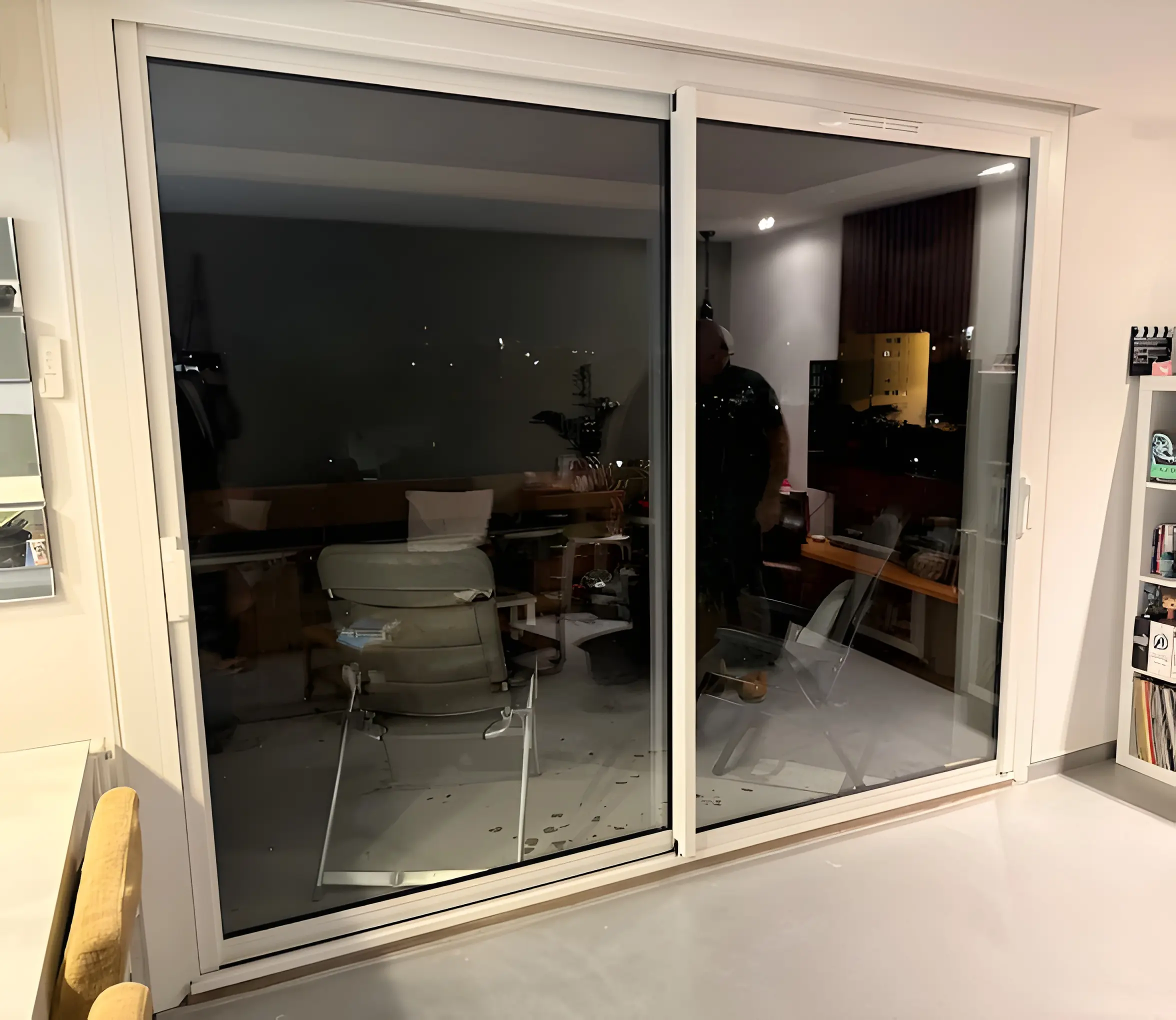 Baie coulissante blanche à deux vantaux dans le séjour d’un appartement
