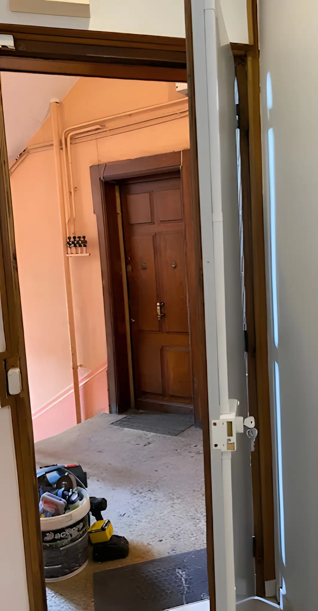 Serrure multipoints en applique posée sur une porte d’appartement, tringles le long du chant